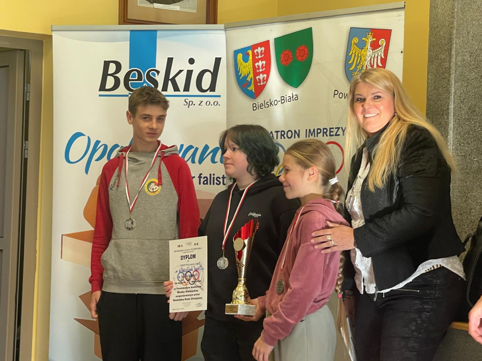 Na zdjęciu stojący ludzie 