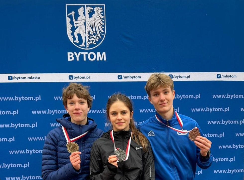 Na zdjęciu stojący ludzie 