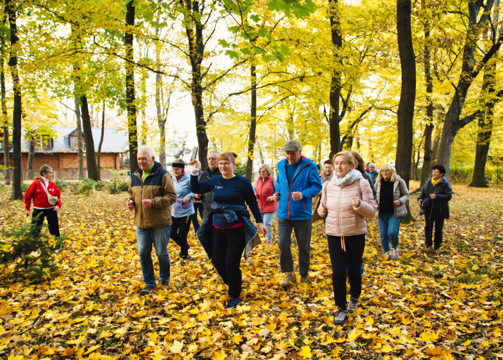 Na zdjęciu stojący ludzie 
