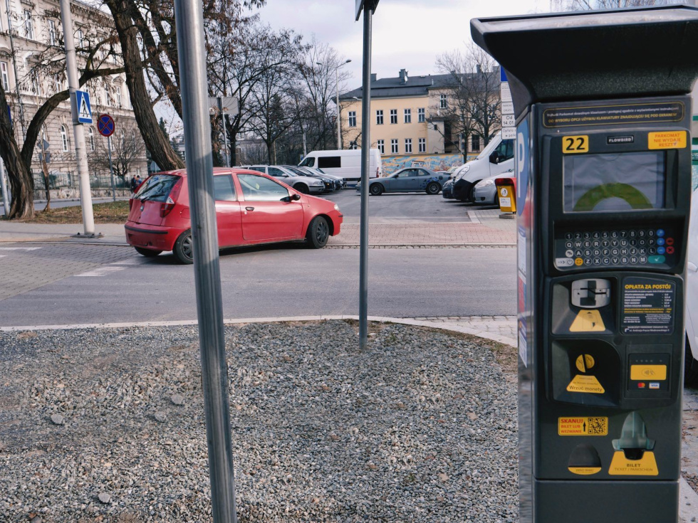 Na zdjęciu parkometr i widok na parking