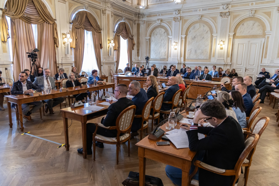 Na zdjęciu siedzący ludzie 