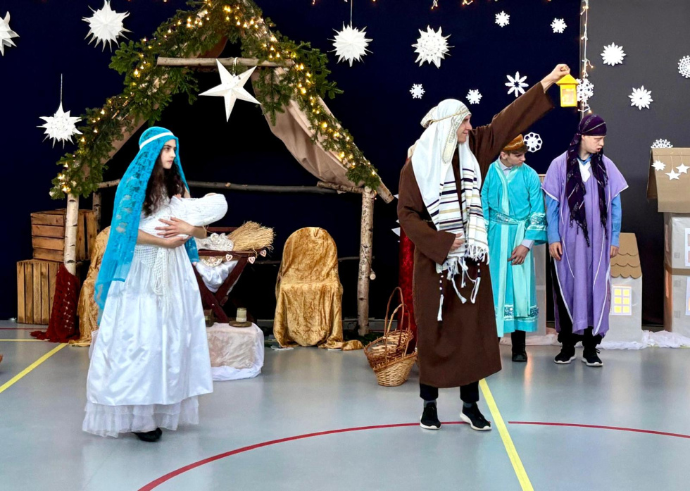 Na zdjęciu stojący ludzie 