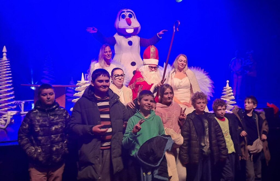 Na zdjęciu stojący ludzie 