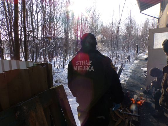 Na zdjęciu stojący ludzie 