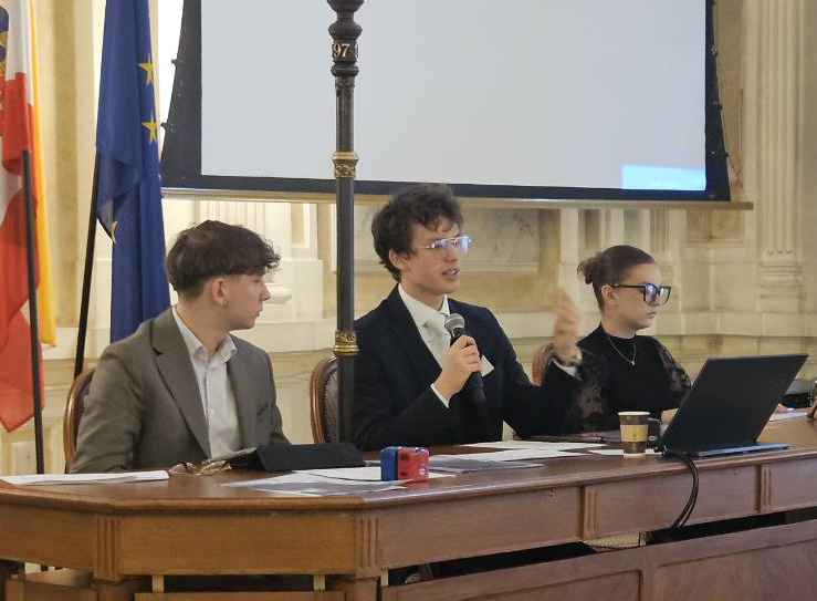 Na zdjęciu siedzący ludzie 