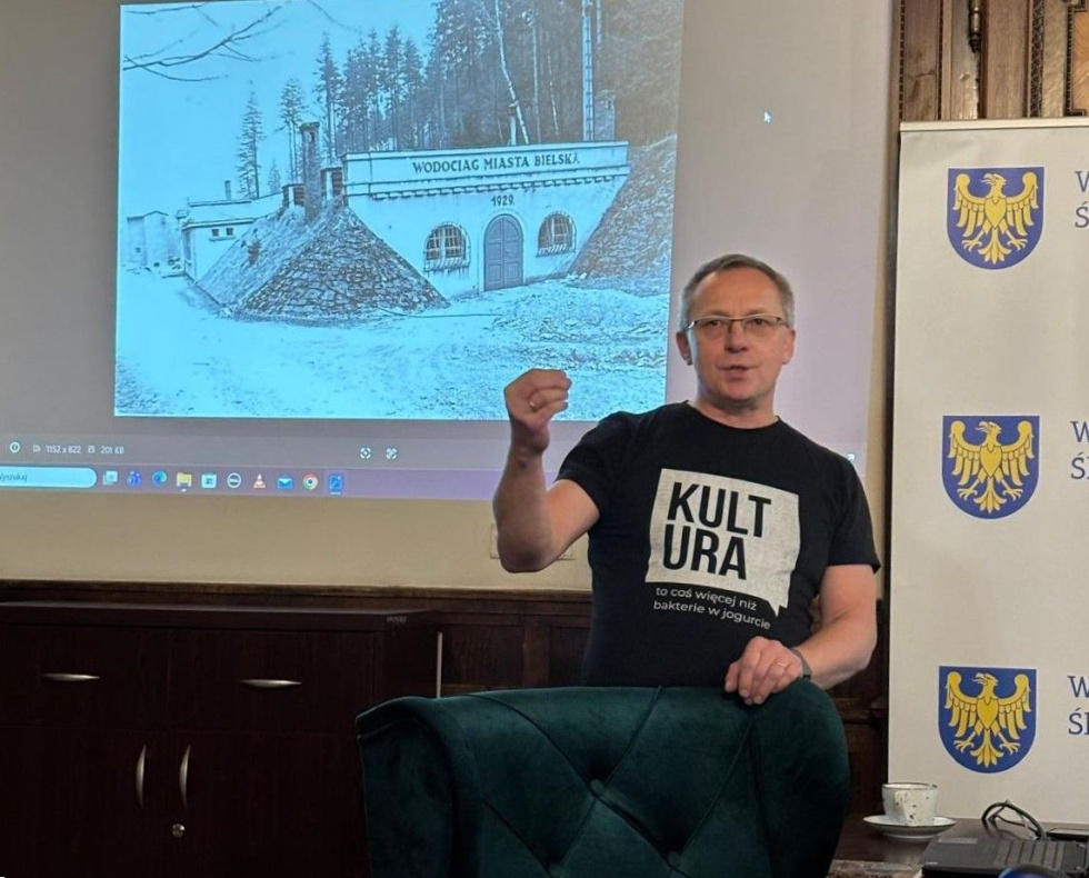 Na zdjęciu Jacek Kachel, za nim archiwalne zdjęciu