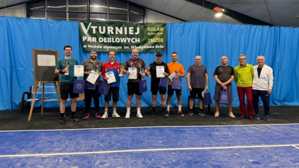 Na zdjęciu stojący ludzie 