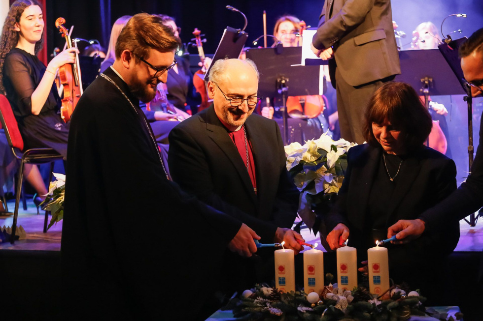 Na zdjęciu stojący ludzie 