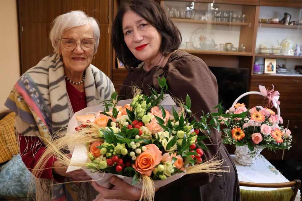 Na zdjęciu stojący ludzie 