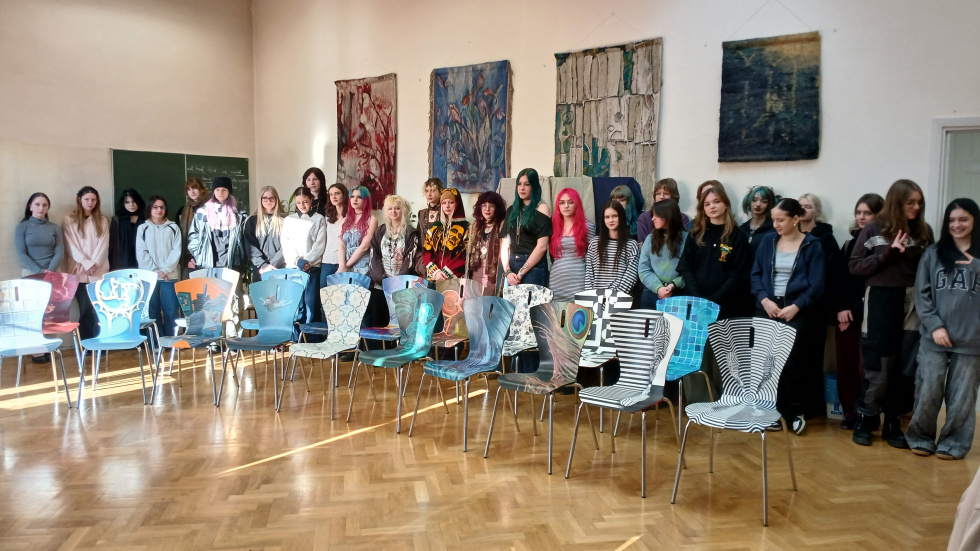 Na zdjęciu stojący ludzie 