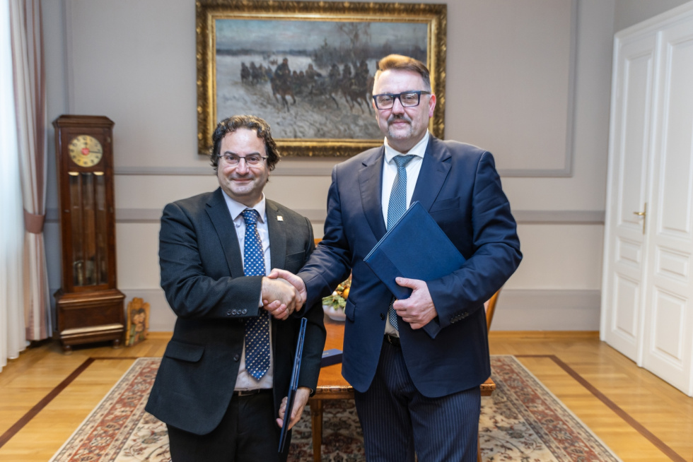 Na zdjęciu stojący ludzie 