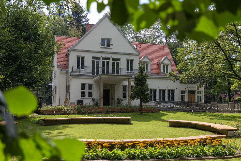 Na zdjęciu budynek willowy w ogrodzie