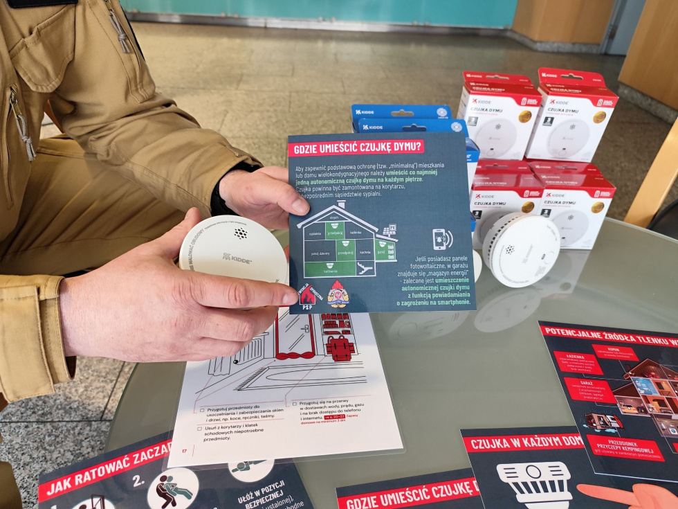 Na zdjęciu strażak i czujki dymu 