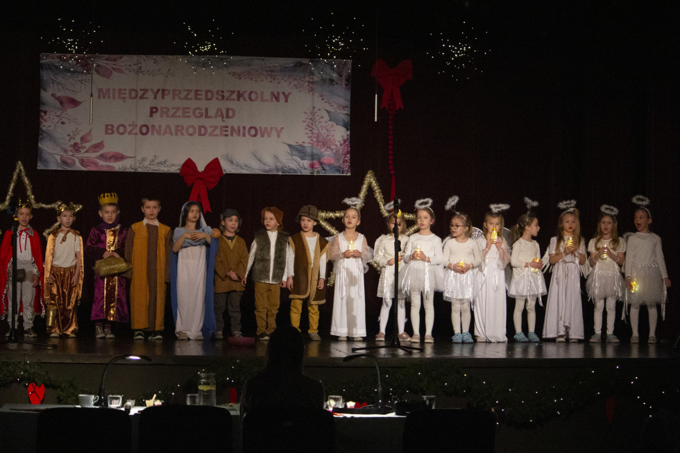 Na zdjęciu stojący ludzie 