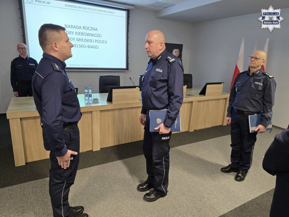 Na zdjęciu stojący ludzie 