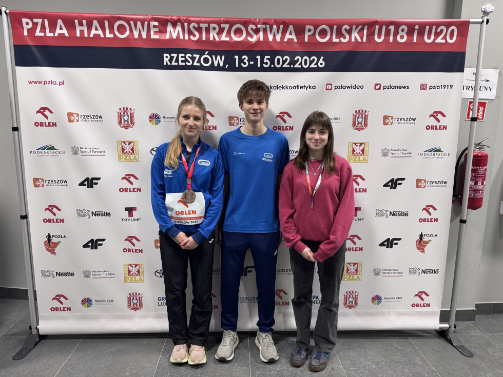 Na zdjęciu stojący ludzie 