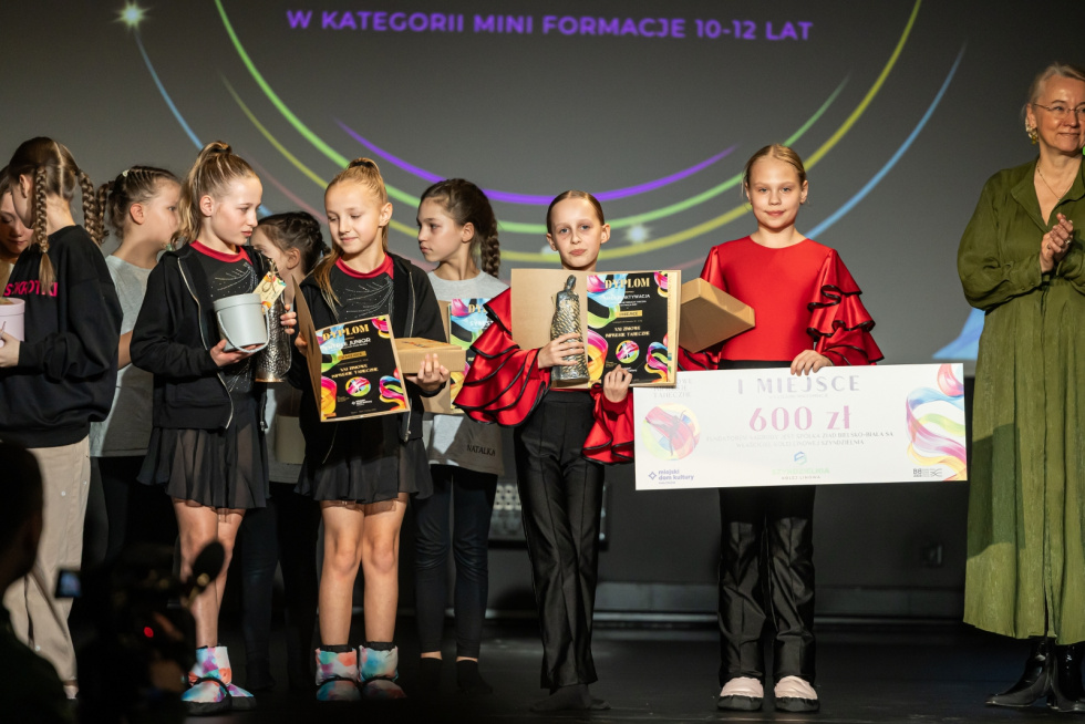 Na zdjęciu stojący ludzie 