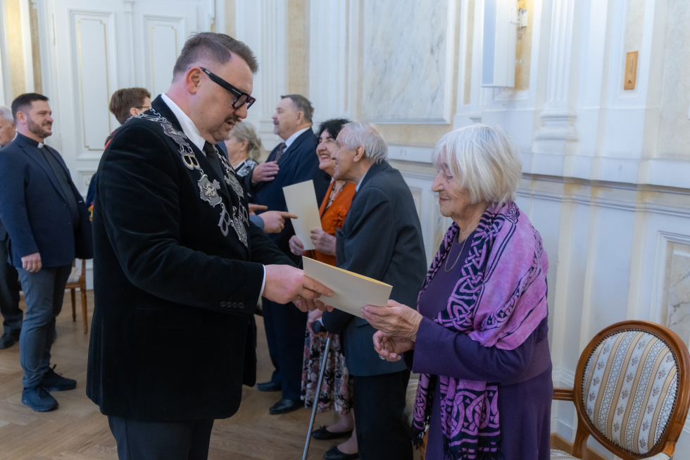 Na zdjęciu stojący ludzie 