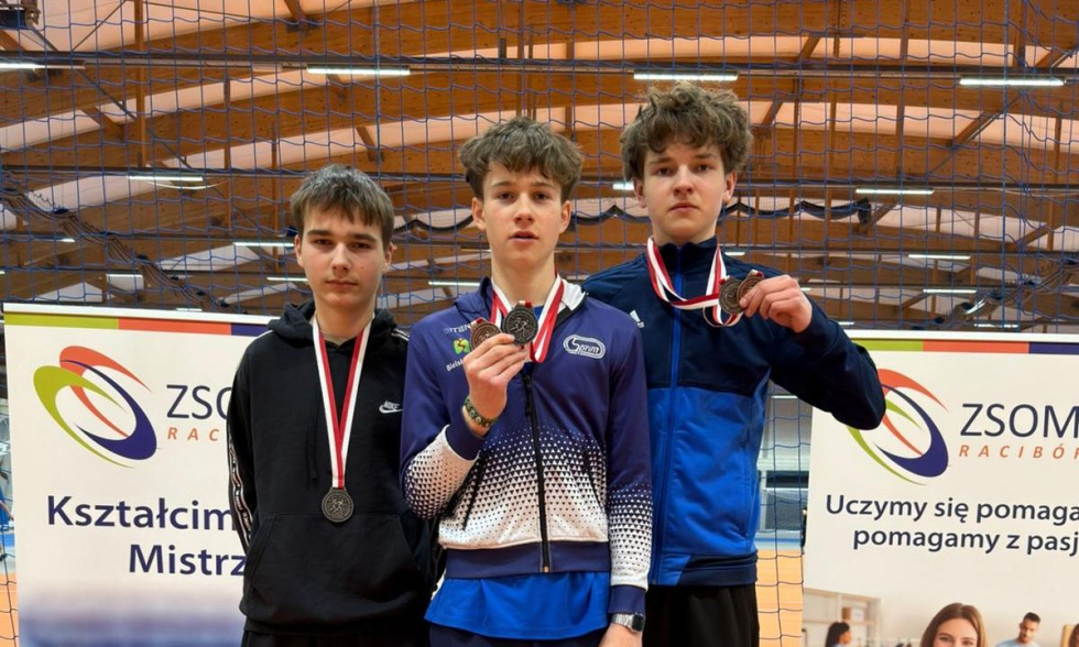 Na zdjęciu stojący ludzie 