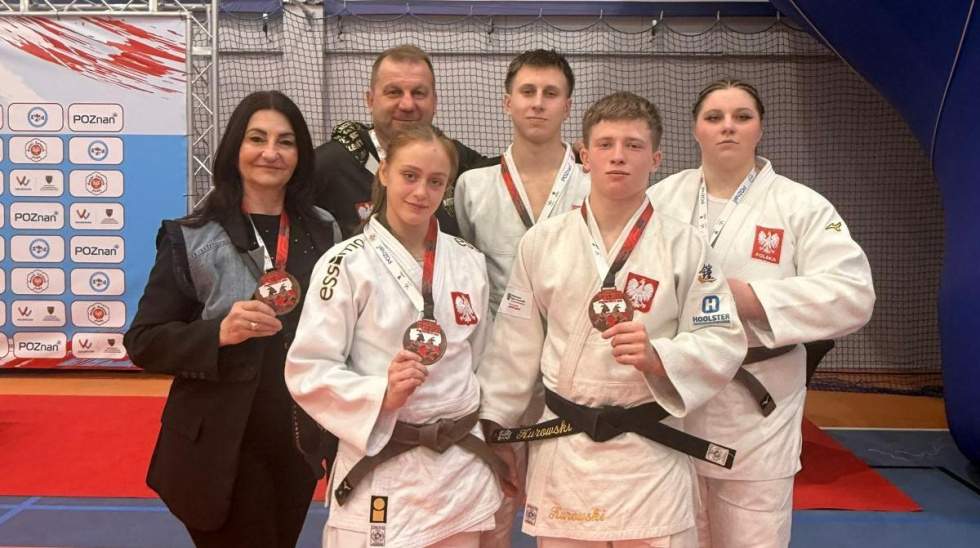 Na zdjęciu stojący ludzie 