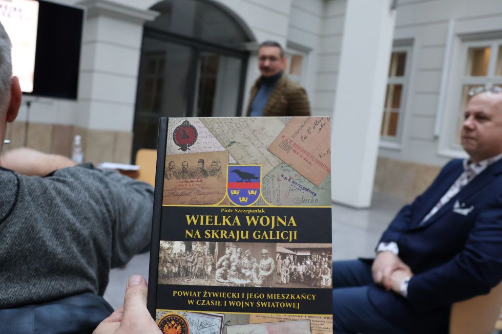 Na zdjęciu stojący ludzie 