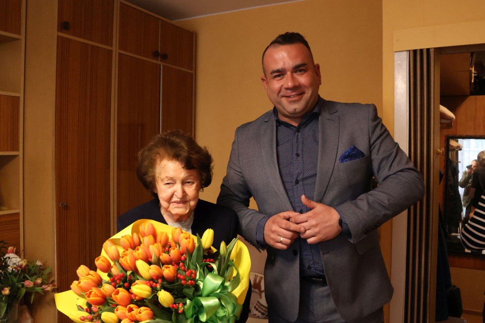 Na zdjęciu stojący ludzie 