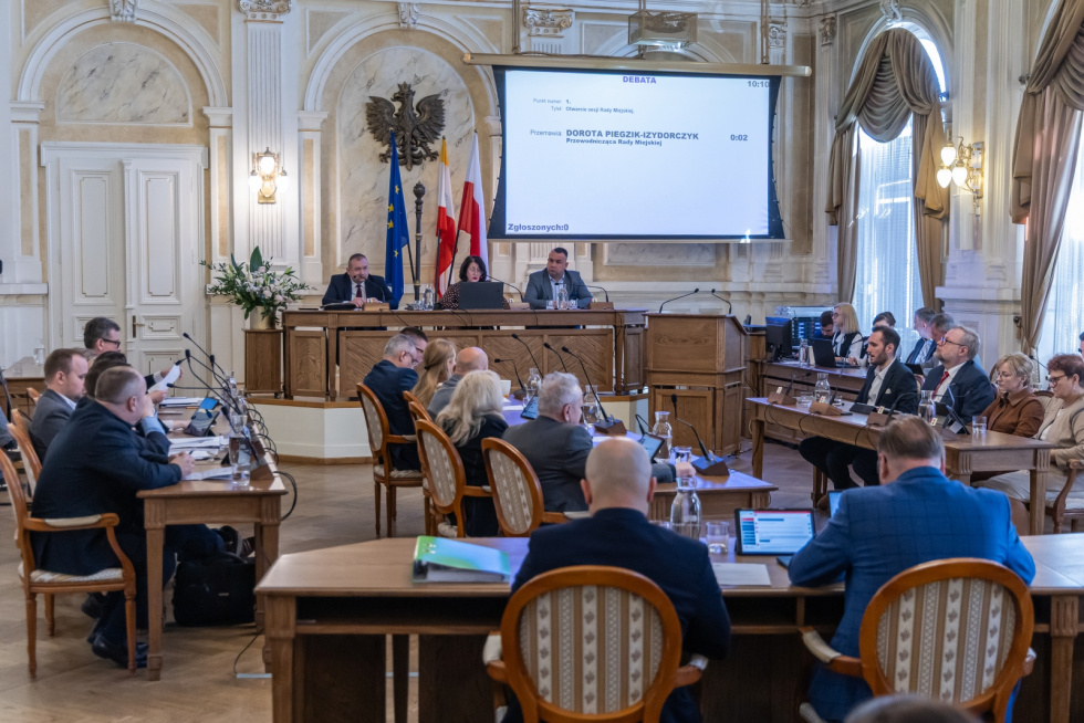 Na zdjęciu siedzący ludzie 