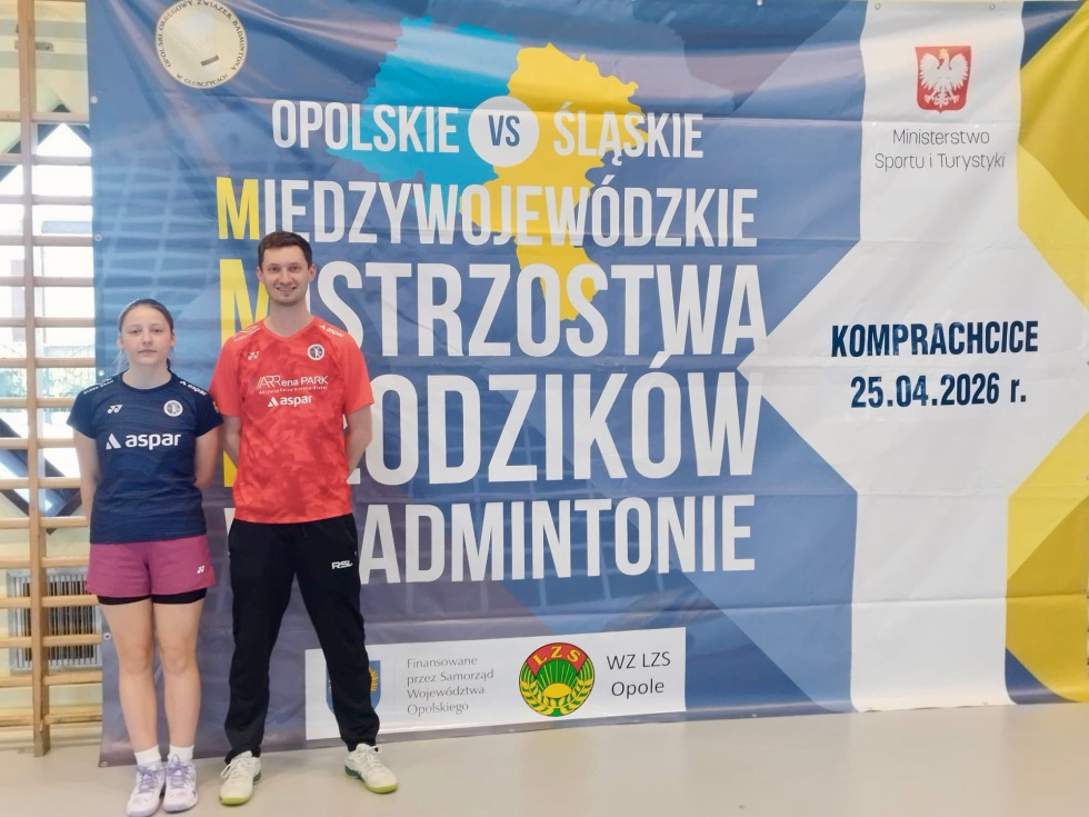 Na zdjęciu stojący ludzie 