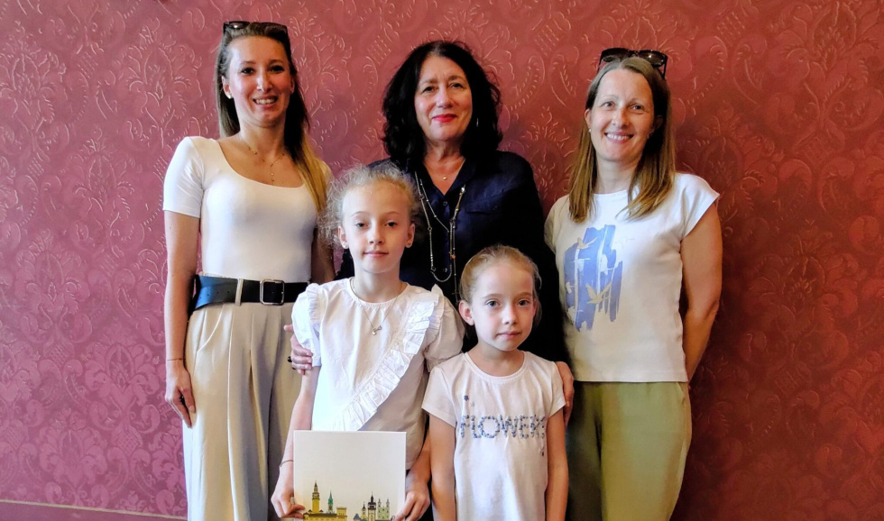 Na zdjęciu stojący ludzie 