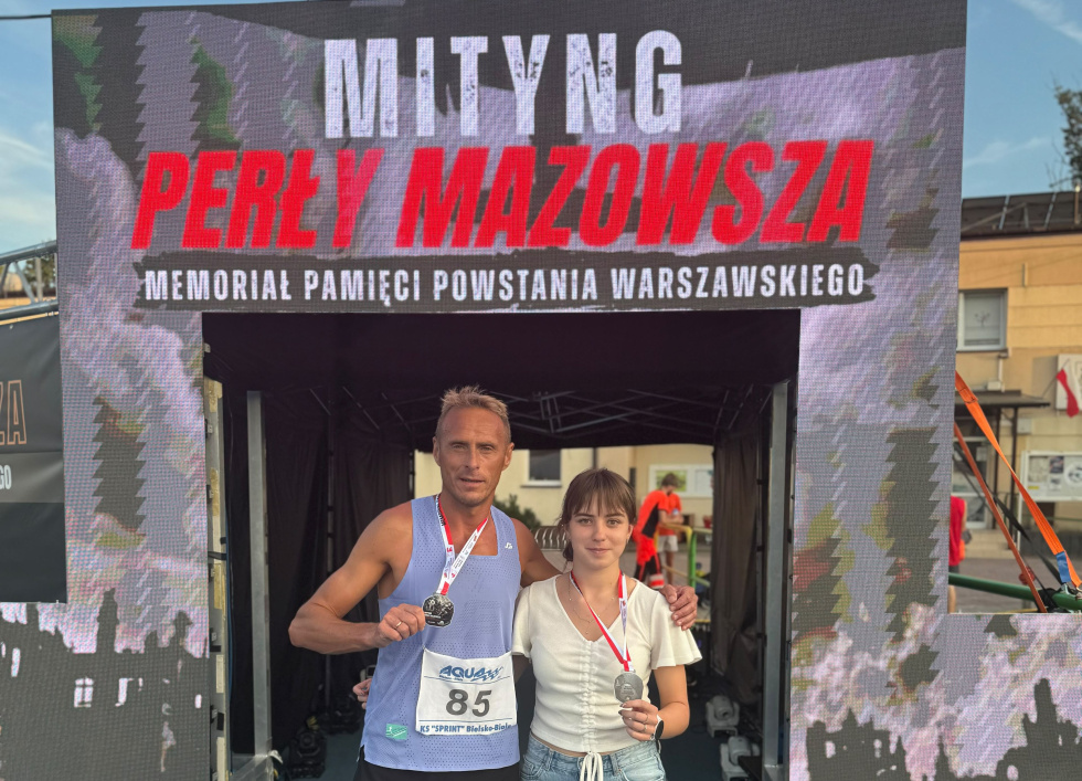 Na zdjęciu stojący ludzie 