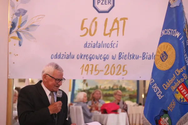 Na zdjęciu stojący ludzie 