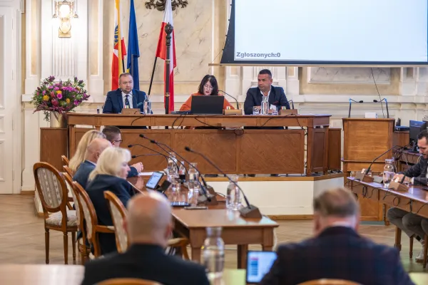 Na zdjęciu siedzący ludzie 