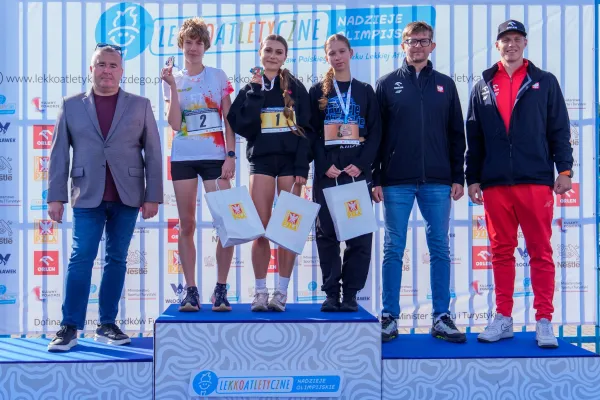 Na zdjęciu stojący ludzie 