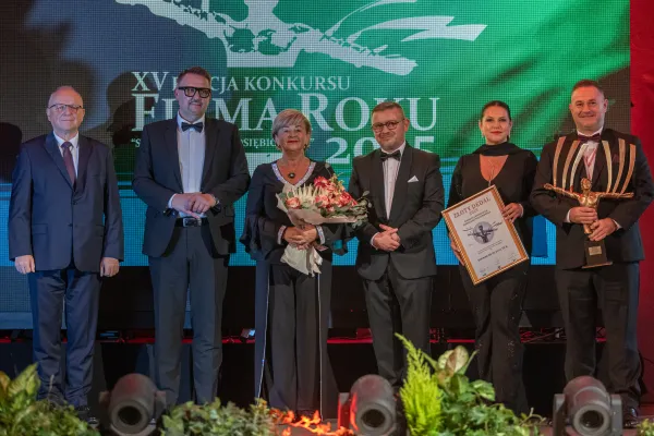 Na zdjęciu stojący ludzie 