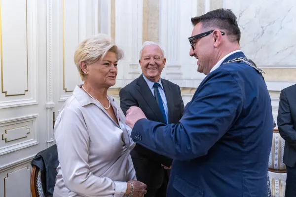 Na zdjęciu stojący ludzie 