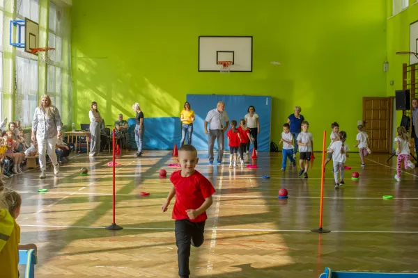 Na zdjęciu stojący ludzie 