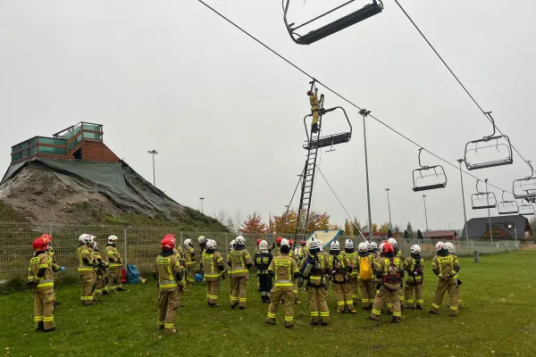 Na zdjęciu stojący ludzie 