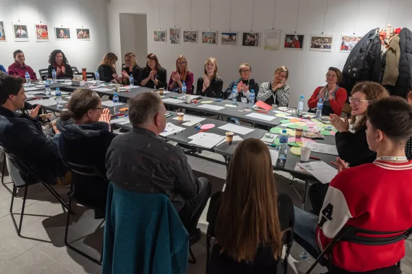 Na zdjęciu osoby siedzące wokół stołu podczas warsztatów 