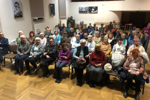 Na zdjęciu siedzący ludzie 