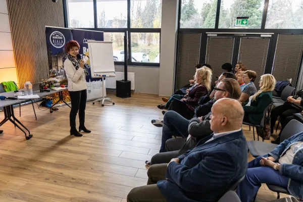 Na zdjęciu siedzący ludzie 