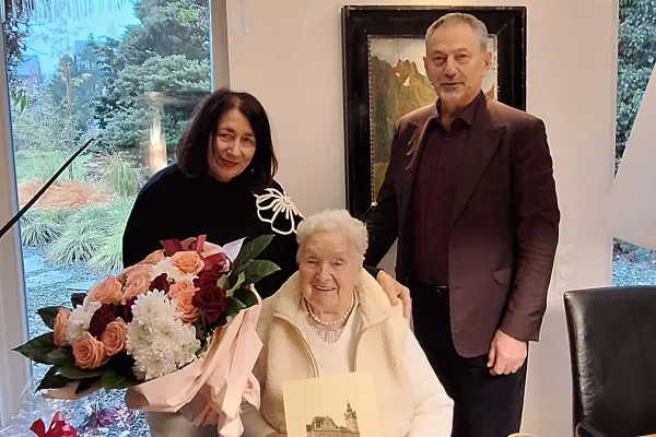 Na zdjęciu stojący ludzie 