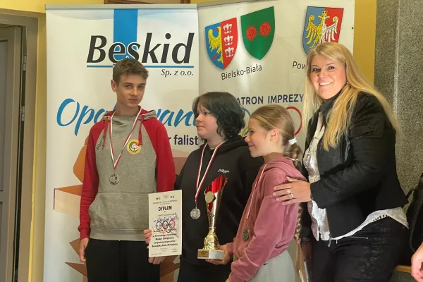 Na zdjęciu stojący ludzie 