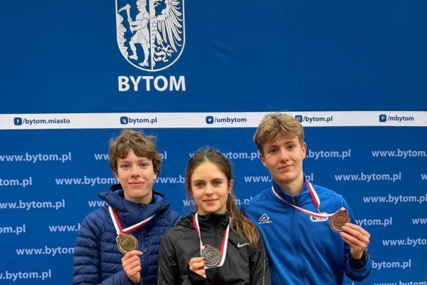 Na zdjęciu stojący ludzie 