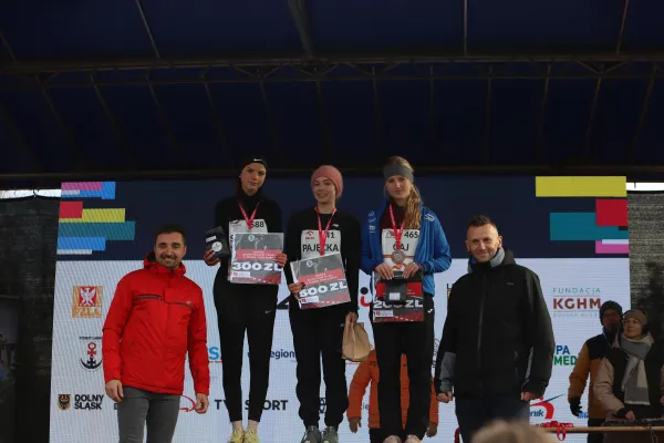 Na zdjęciu stojący ludzie 