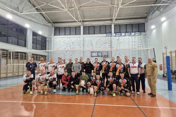 Na zdjęciu stojący ludzie 