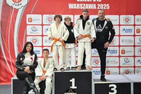 Na zdjęciu stojący ludzie 