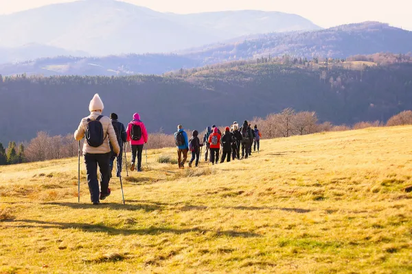 Na zdjęciu stojący ludzie 