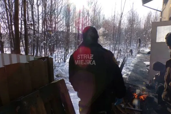 Na zdjęciu stojący ludzie 