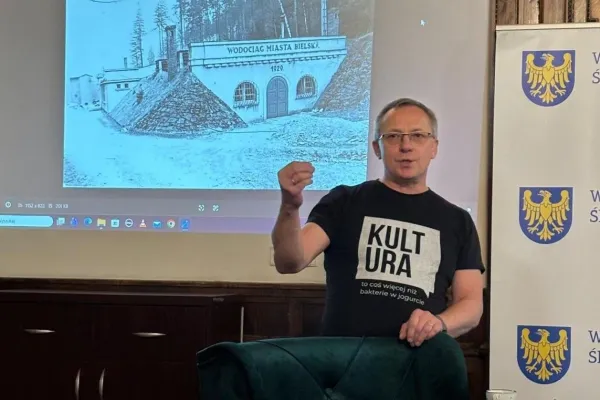 Na zdjęciu Jacek Kachel, za nim archiwalne zdjęciu