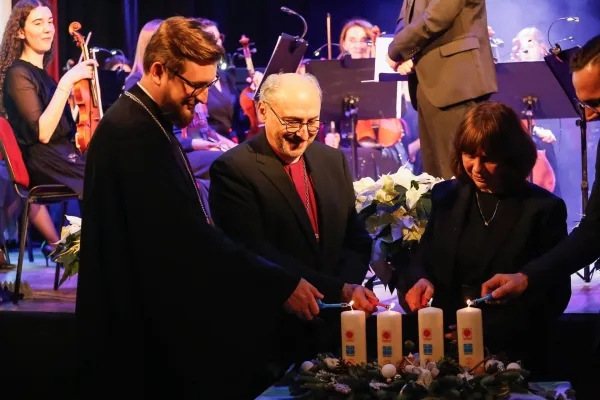 Na zdjęciu stojący ludzie 